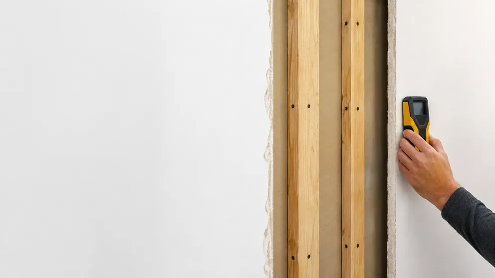 Cutaway view of a wall showing studs and fasteners with a stud finder detecting them
